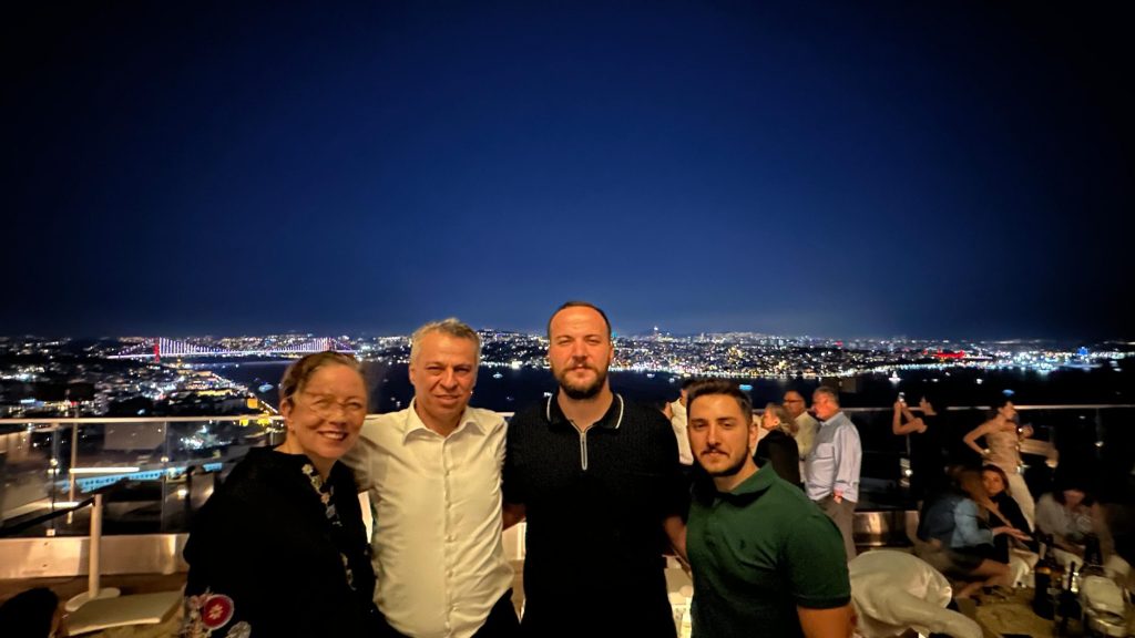 Gece şehir ışıklarına karşı poz veren dört kişi