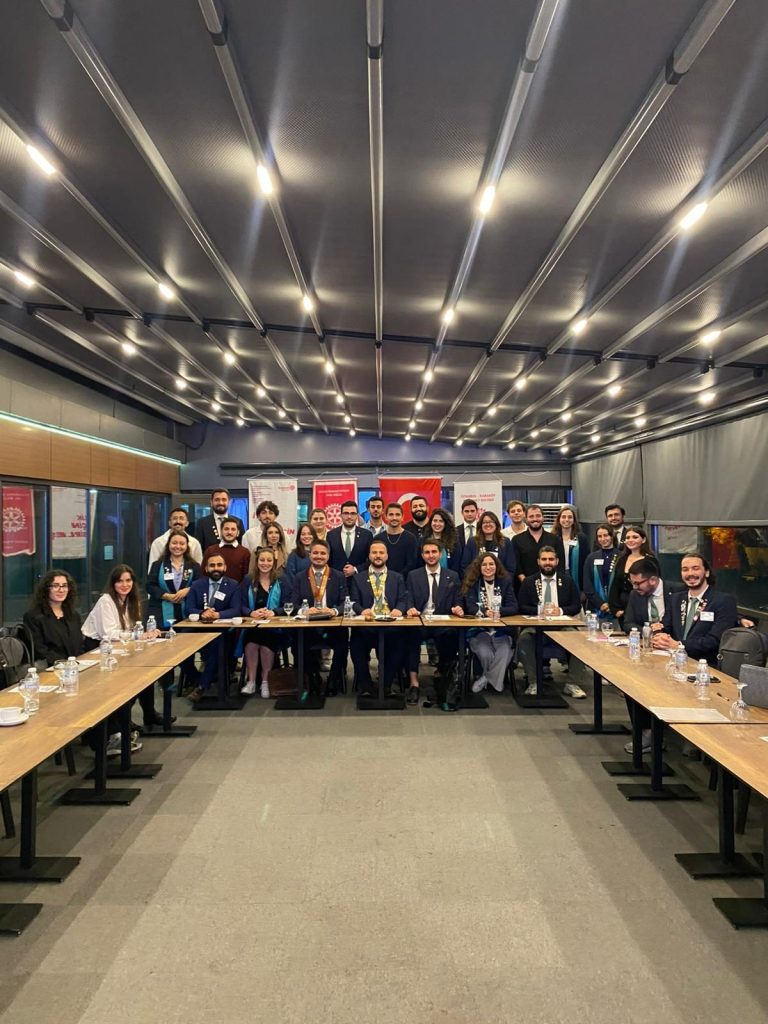U düzenli masalarda oturan toplantı katılımcıları