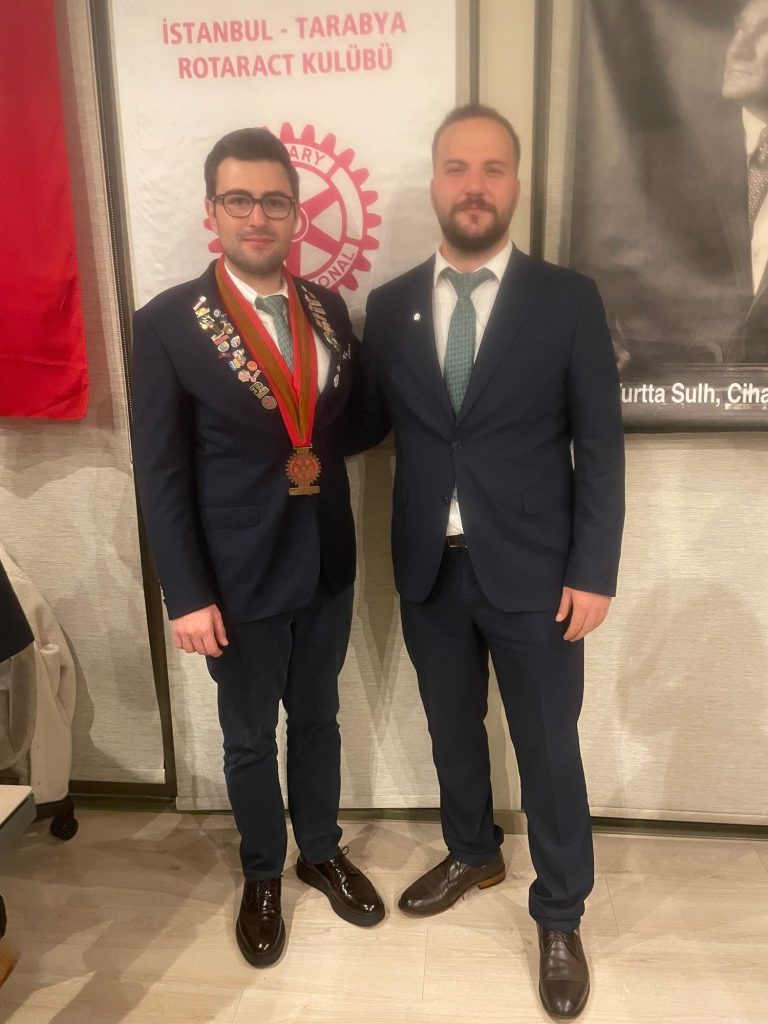 Tarabya Rotaract flaması önünde iki kişi