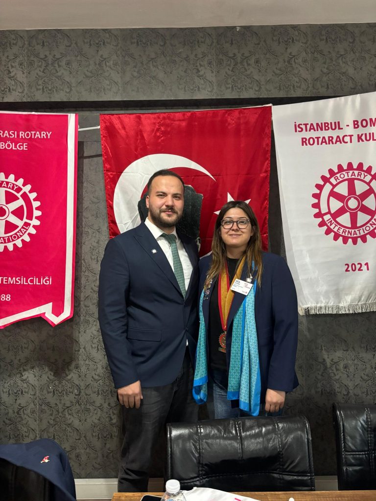 Bayrak ve kulüp flamaları önünde iki kişi