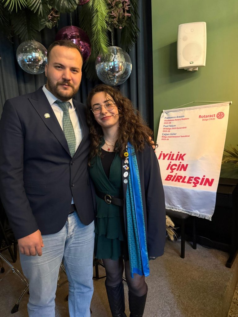 İyilik İçin Birleşin panosu yanında iki kulüp üyesi