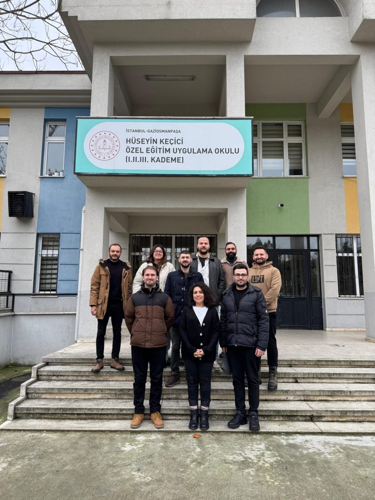 Bir özel eğitim okulunun giriş merdivenlerinde kulüp üyeleri
