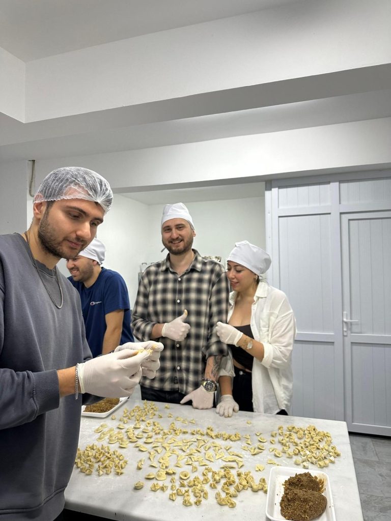 Bone takmış gönüllüler tezgâhta mantı kapatıyor