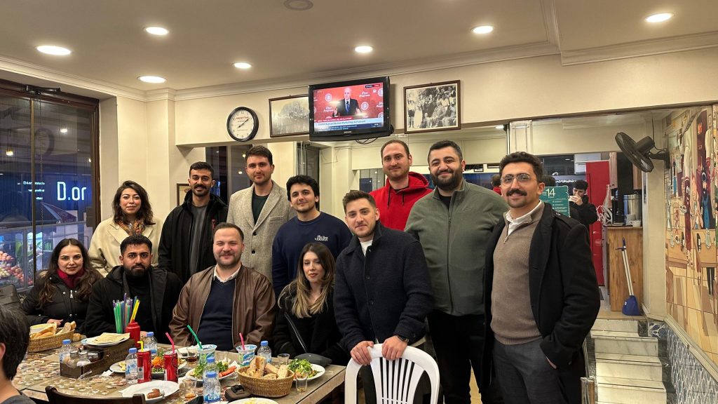 Kalabalık bir masa etrafında toplu fotoğraf