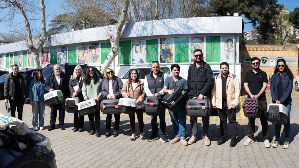Ellerinde kutularla açık havada sıralanmış gönüllüler