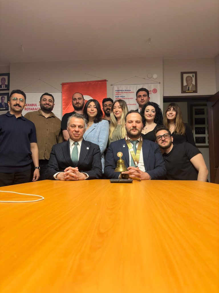 Toplantı masası etrafında toplanmış kulüp üyeleri ve konuk