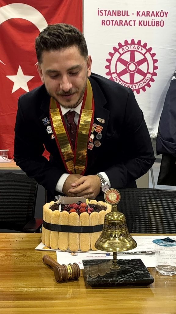 Kulüp flaması önünde pasta ve zil başında kulüp başkanı