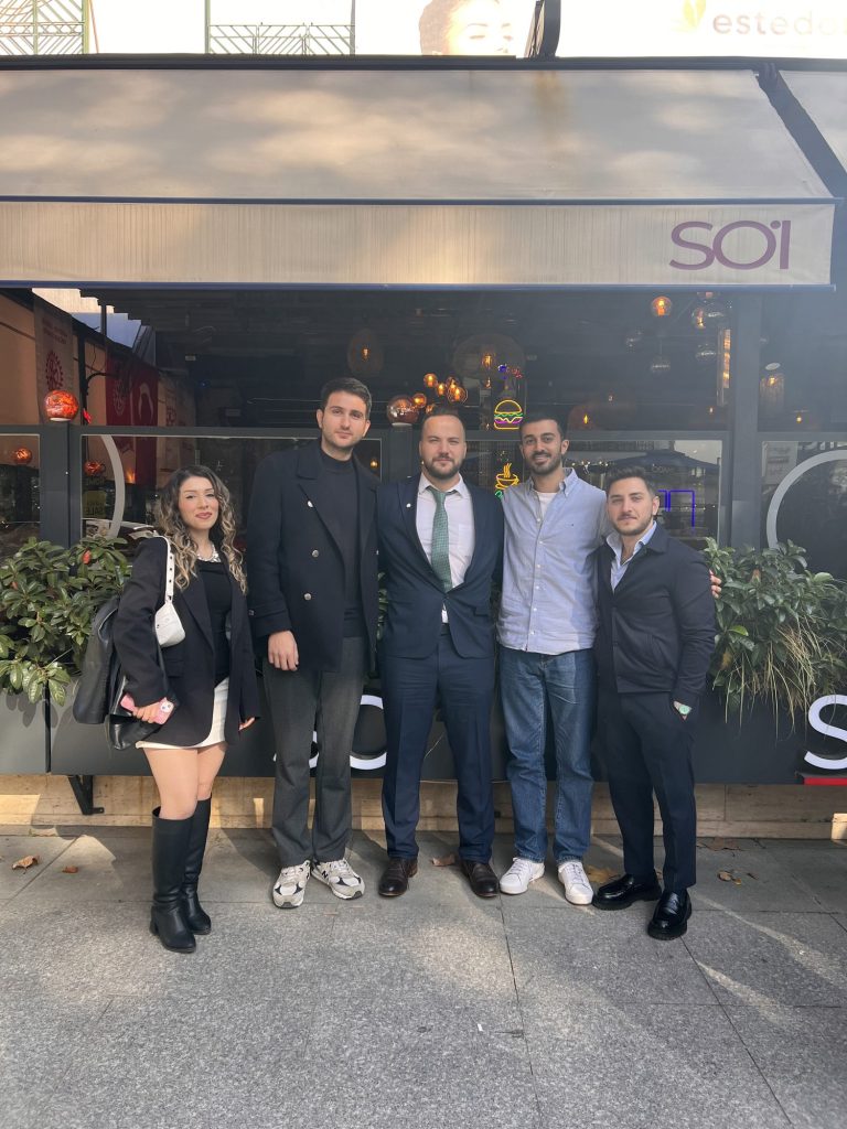 Bir restoranın önünde poz veren beş kişi