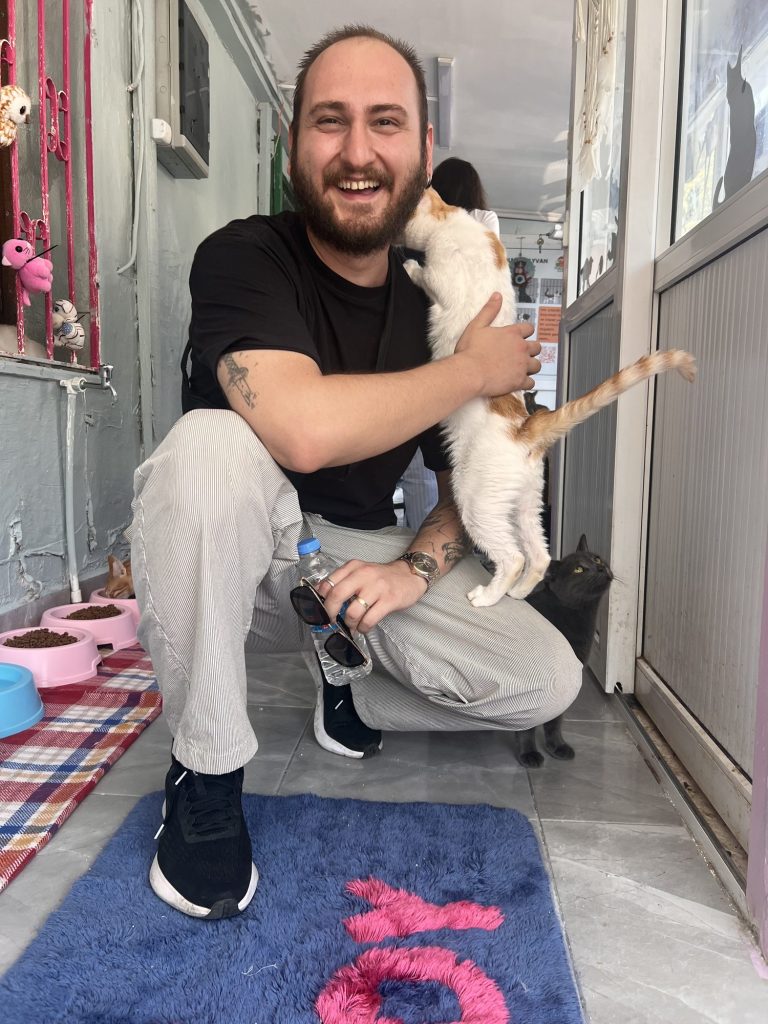 Kucağında kediyle gülümseyen bir kulüp üyesi