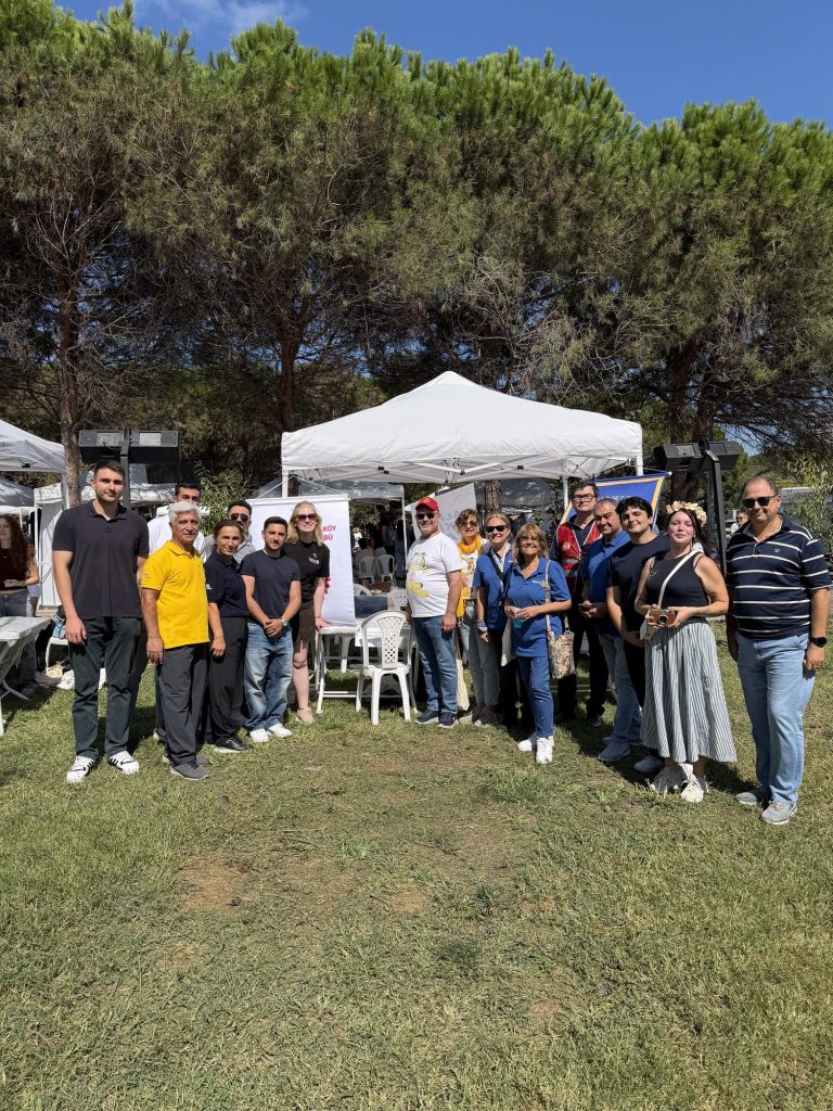 Çadırların önünde çimenlikte toplu fotoğraf veren gönüllüler
